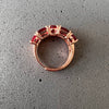 Vista cenital de anillo de oro rosa con piedras rojas grandes