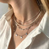 Layering de cadenas de plata y collar de perlas