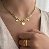 Escote de mujer con collar de cadena y 3 corazones y dos anillos alianza dorados