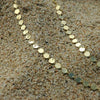 Collar de placas doradas sobre la arena de la playa