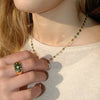 Escote de mujer con un collar de estrellas de plata dorada y un anillo de oro