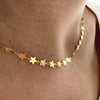 Escote de mujer con un collar de estrellas de plata dorada