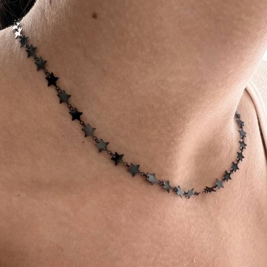 Escote de mujer con un collar de estrellas de plata bañada en rutenio