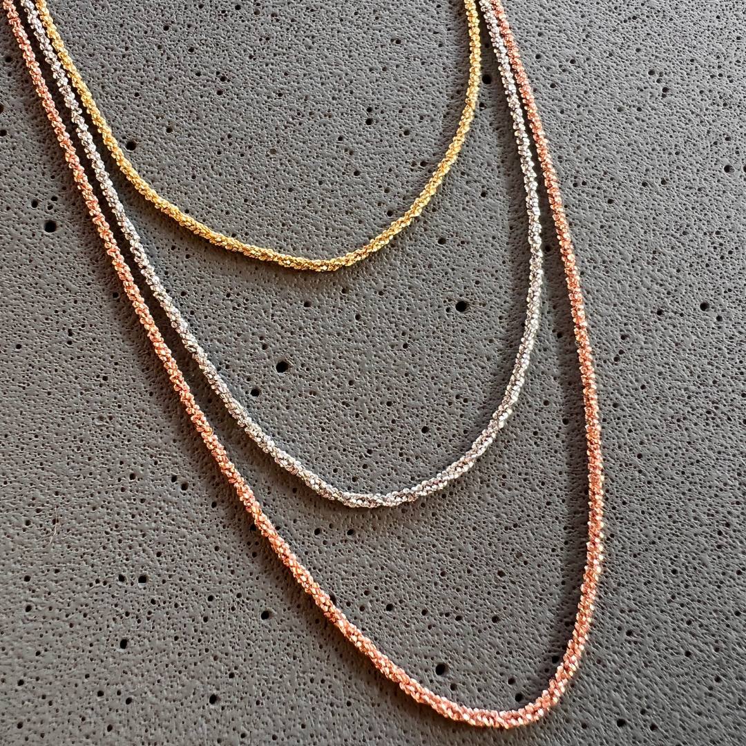 Detalle de collar con 3 cadenas de cordón en oro amarillo, oro rosa y plata