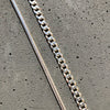cadena barbada de plata y cadena de cola de topo sobre fondo gris