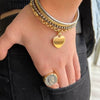 Mano de mujer en el bolsillo con pulseras de plata y anillo sello